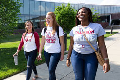 Three happy students walking side by side on a sunny day on the IU Columbus campus.